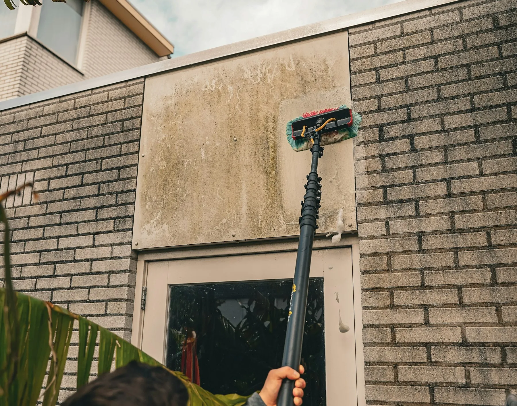Nettoyage de la façade d'un bâtiment à la brosse télescopique
